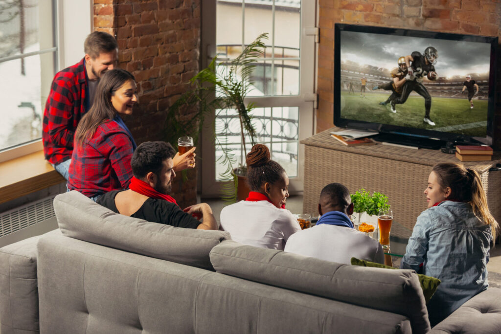 Friends watching a live sports match at home on KemoTivi IPTV